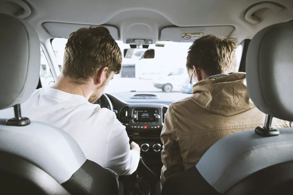 Zwei junge Menschen nebeneinander im Auto